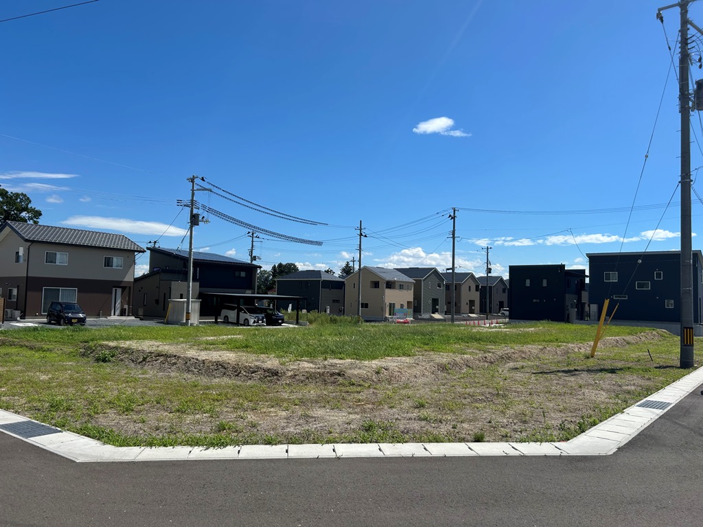 スマートハイムシティ箱崎の分譲地、区画4の写真。周囲には新しい家々が立ち並び、電柱や電線が空に伸びています。穏やかで明るい日差しが降り注ぎ、静かな住宅エリアの雰囲気が漂っています。