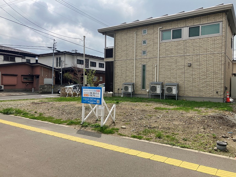 交差点の角にある古い建物と新しい建物。看板が正面に見えます。