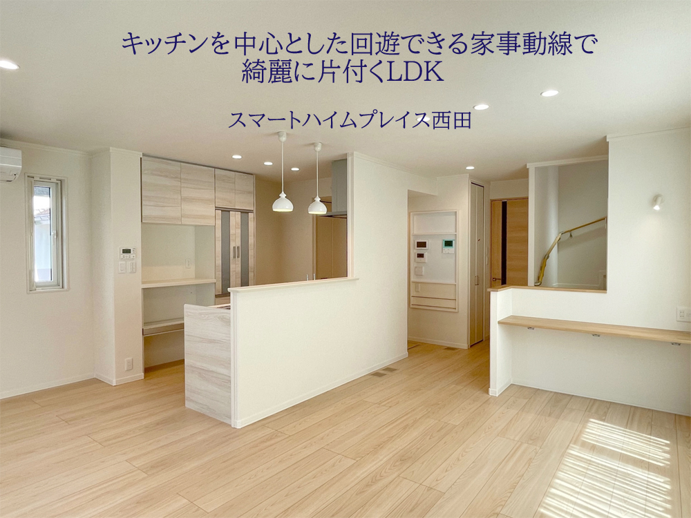 白と木目調を基調としたリビングダイニングキッチン。奥には2階への階段が見えます。