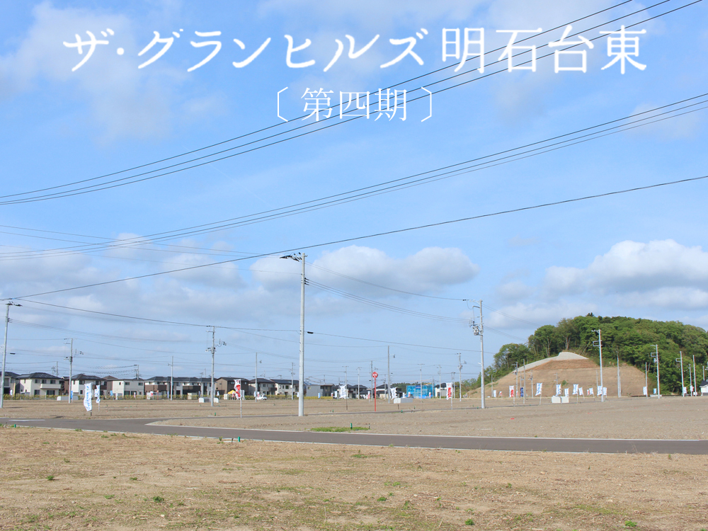 ザ・グランヒルズ明石台東。広い分譲地と電柱が立ち並ぶ住宅地。背景には住宅地と丘陵地が見えます。