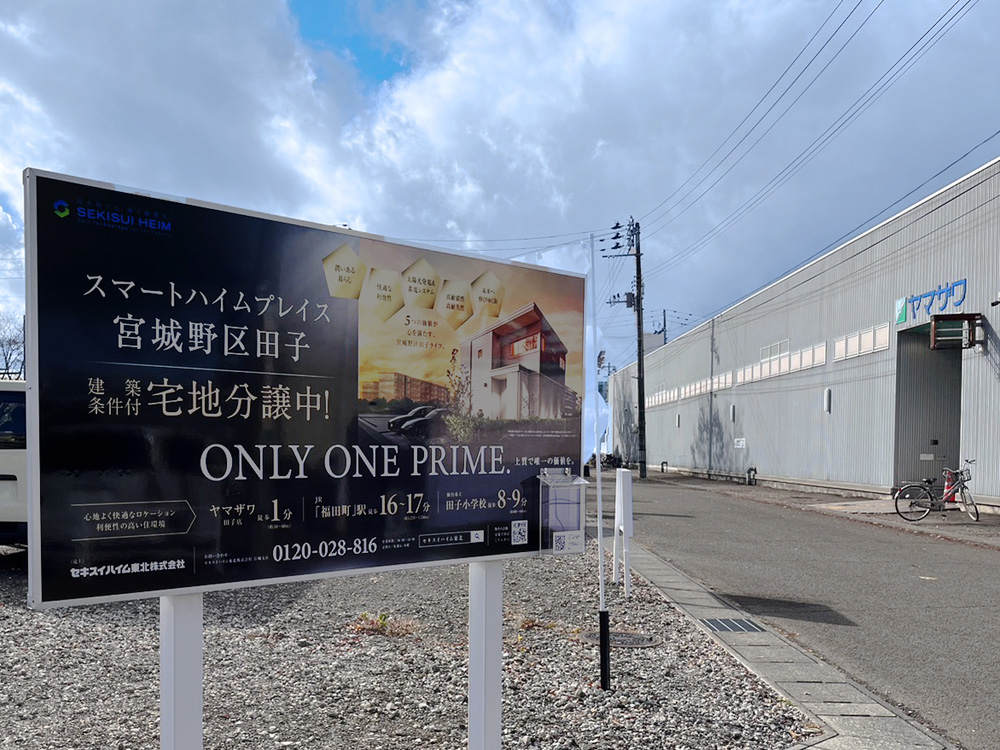 スマートハイムプレイス宮城野区田子宅地分譲中の看板が建てられています。その横にヤマザワ田子店が見えます。