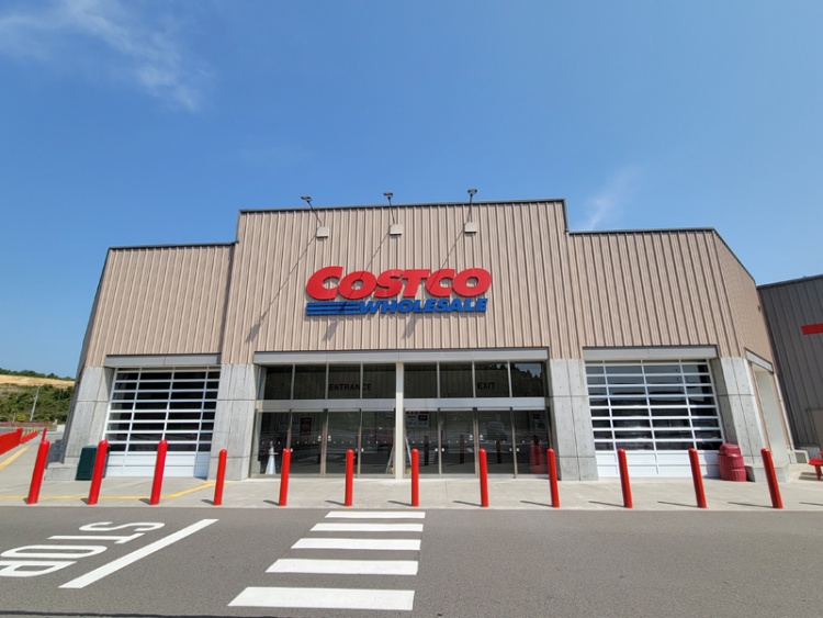 コストコ富谷倉庫店の外観。赤いポールと、COSTCO WHOLESALEの看板が見えます。