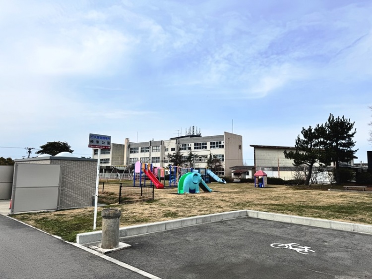 広場に遊具が置かれた袖東公園の外観。手前には駐輪マークがあります。