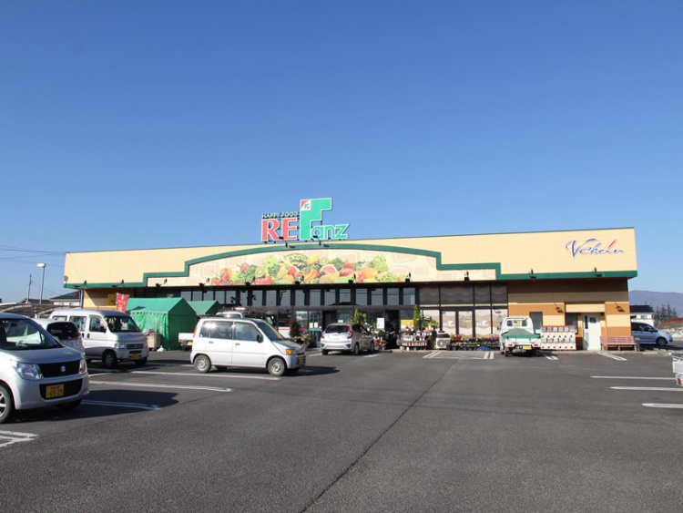 広い駐車場を備えた食品スーパーマーケットファンズ保原店の外観。駐車場には数台の車が駐車されています。