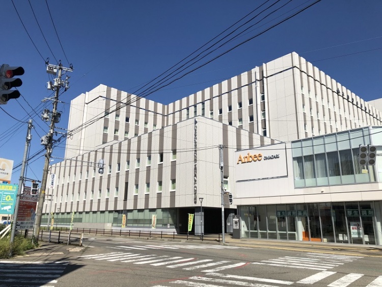 白い外観の大きな建物で、大曲厚生医療センターと書かれている病院の正面。交差点に位置しています。