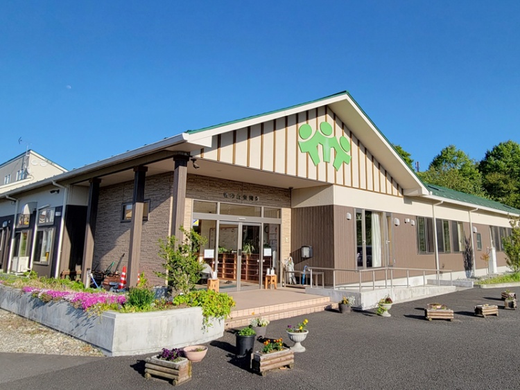 ブラウンの平屋建物が特徴的な杜の丘保育園の外観。建物周囲には花壇が植えられています。