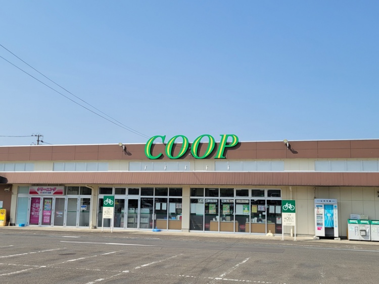 緑の文字が特徴的な宮城生協大富店の外観。駐車場と自転車置き場が見えます。