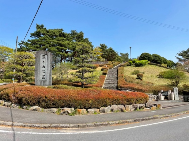 階段のある広い丘と石碑が特徴的なの翠ヶ丘公園の外観。周囲は緑に囲まれています。
