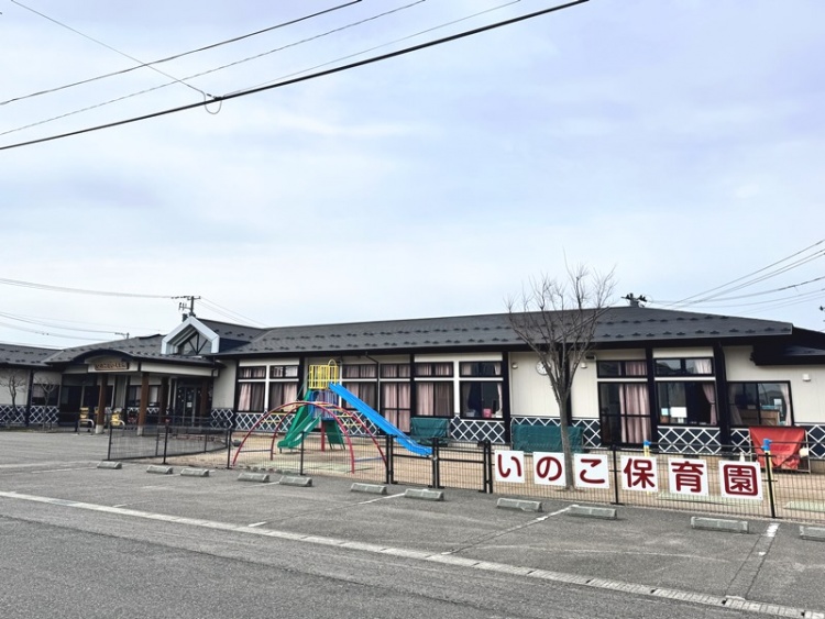 いのこ保育園の外観。フェンスで囲まれた小さな滑り台などが設置されています。