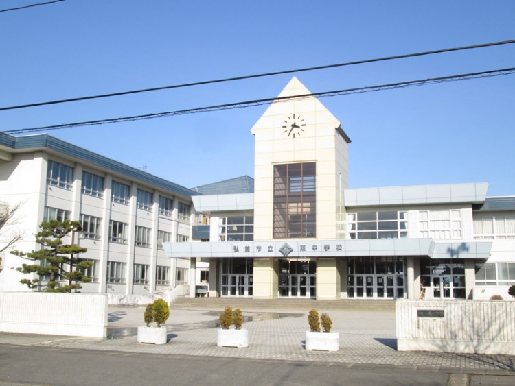 白い校舎で、中央に時計塔がある東中学校の正面玄関です。