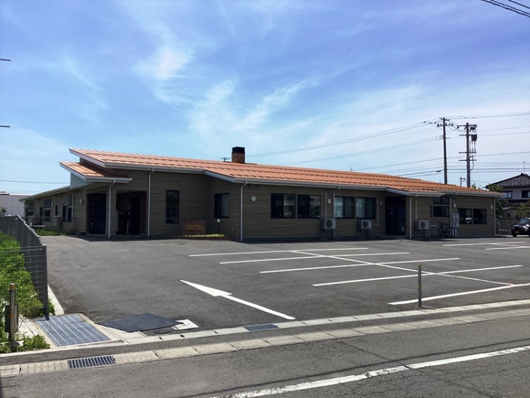 茶色の屋根を持つ平屋の三川りっしょう子ども園の外観。駐車場が見えます。