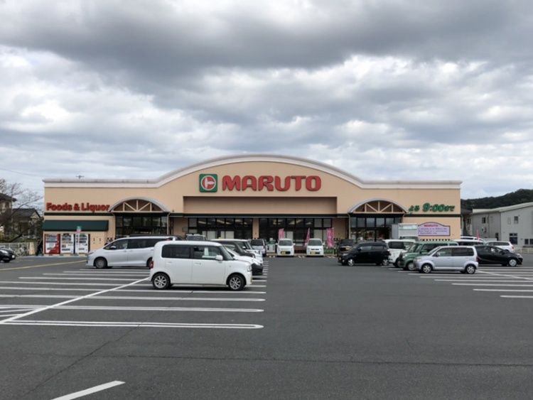 広い駐車場を備えたスーパーマーケットマルト玉川店の外観。建物上部にはFoods & Liquorと書かれています。