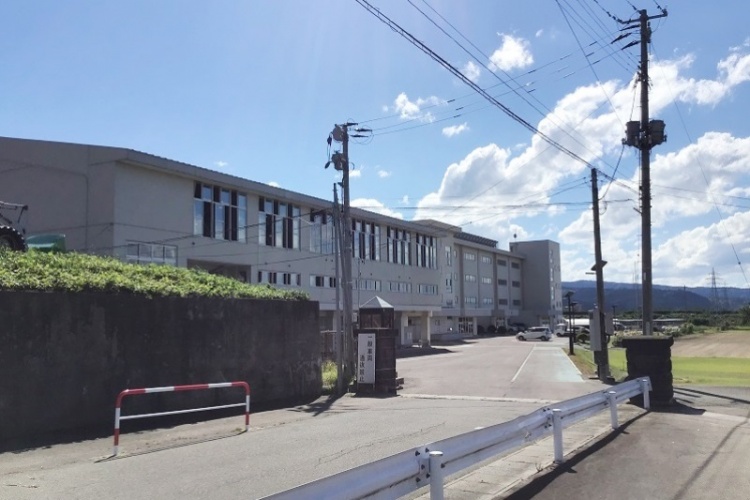 湯沢南中学校の校舎の外観。道路と電柱も写っています。