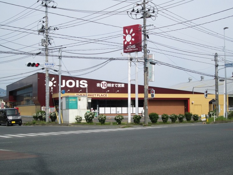 白とえんじ色が特徴的なジョイス見前店の看板があるスーパーマーケット。夜10時まで営業しています。