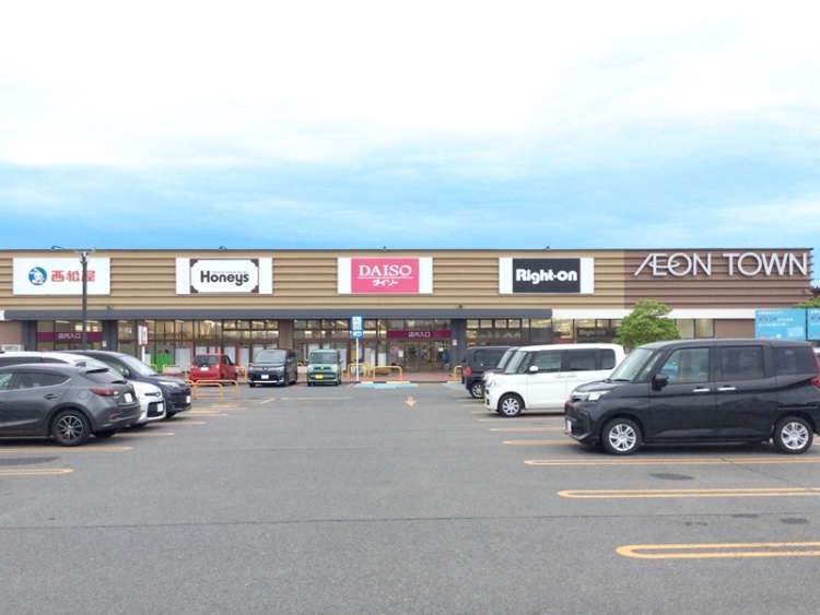 イオンタウン酒田の店舗外観。正面には西松屋やダイソーなどの看板が見え、駐車場に複数の車が停められています。
