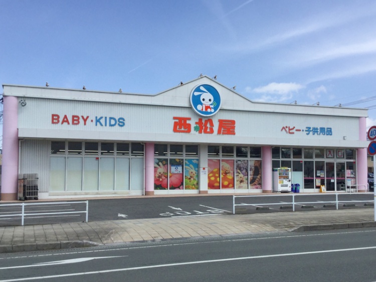 白とピンクの建物の西松屋さくらんぼ東根店の外観。看板にらBABY・KIDSやベビー・子供用品と書いています。
