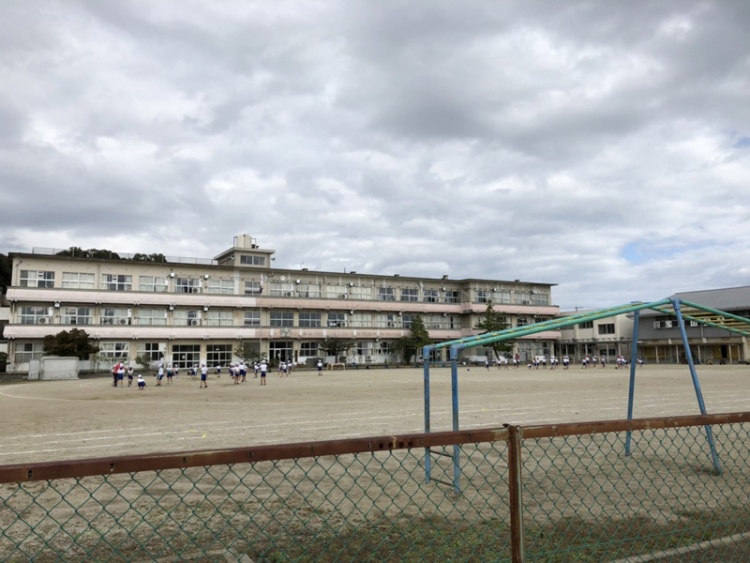 三階建ての小名浜第三小学校の校舎の外観。遊具もあり、背景に大きな校舎が見えます。
