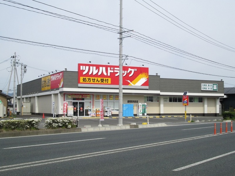 赤と黄色と白が特徴的なツルハドラック盛岡西見前店の外観。大通り沿いに位置しています。