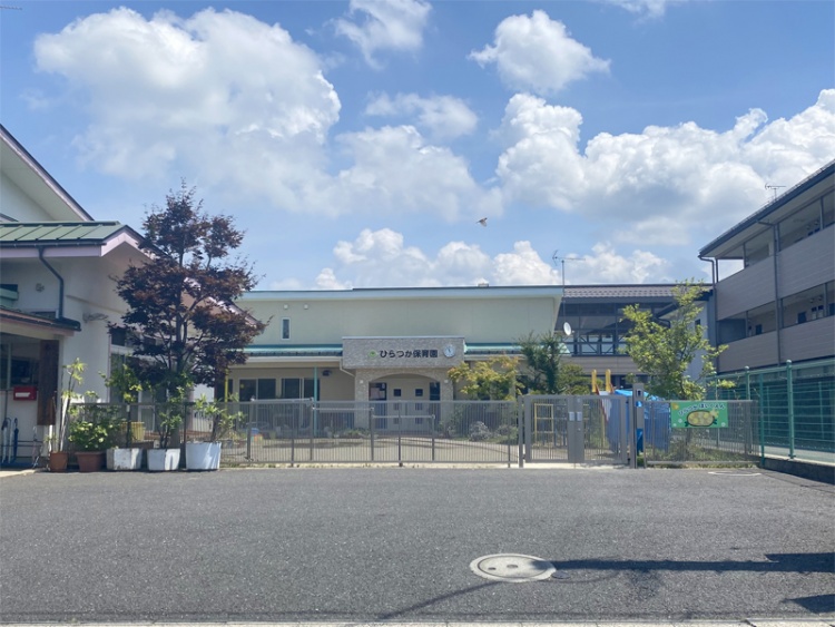 ひらつか保育園の外観。広い敷地に植栽があり、園の入口にはフェンスが設置されています。