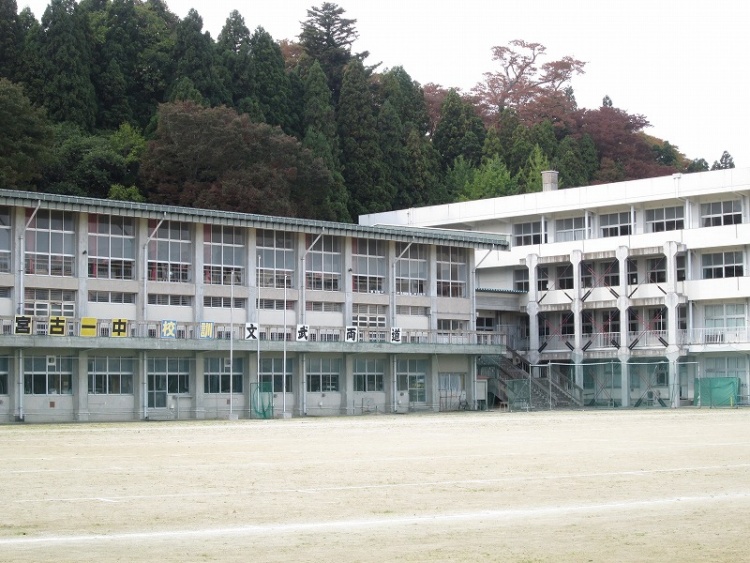 白い外壁の宮古第一中学校の校舎の外観。校舎の正面には、心身ともに健康で、自ら学び、心豊かに、たくましく生きる人間の育成と書かれた標語が掲示されています。