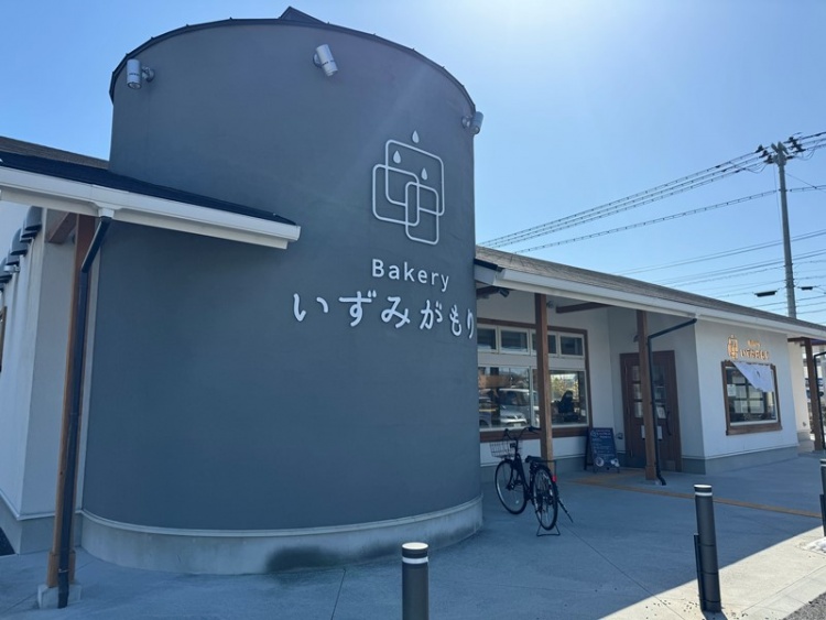 グレーの外壁が特徴的ないずみがもりと書かれたベーカリーの外観。正面には自転車が置かれています。