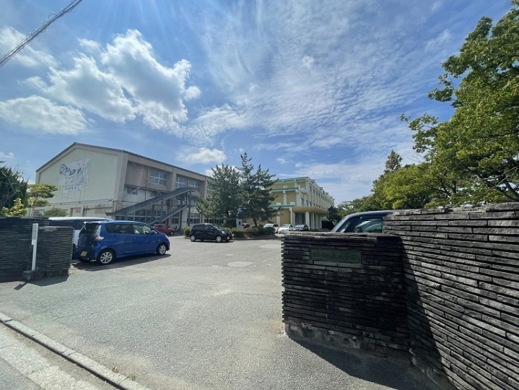 泉小学校の校舎と駐車場の外観。門扉が手前に見えます。