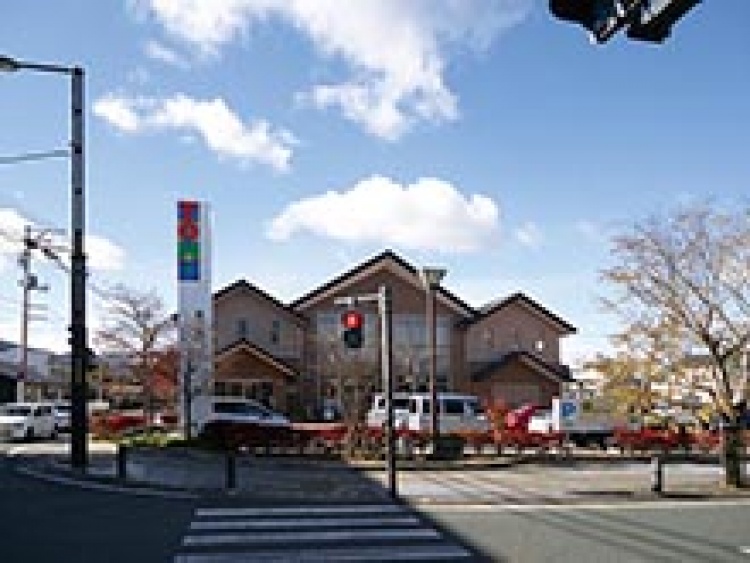 交差点の向こうにある東邦銀行相馬支店の建物の外観。周囲には木々や駐車場には車が停まっています。