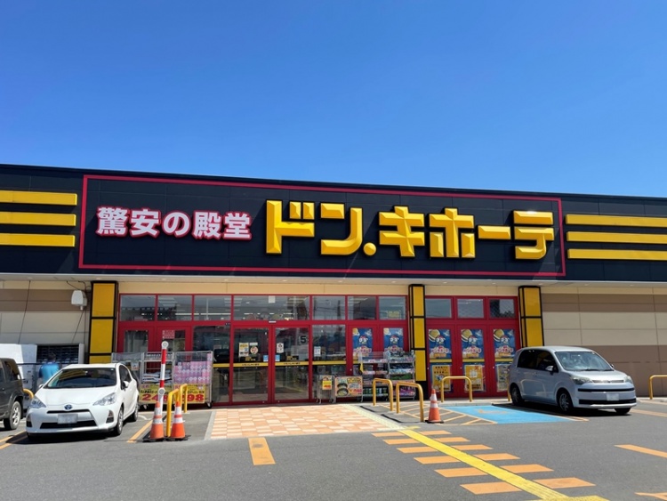 赤と黄色の看板が特徴でドン・キホーテ須賀川店の外観。駐車場には数台の車が停められています。