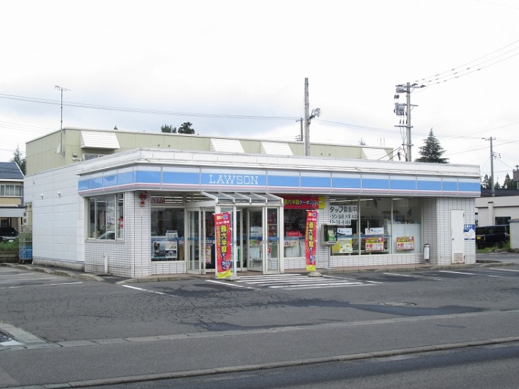 ローソンの外観。入口に広告の旗が立っており、店舗の窓には各種ポスターが貼られています。