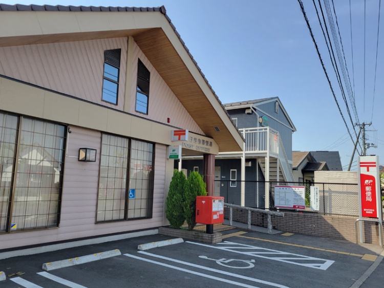 斜めの屋根と大きな窓が特徴的な富谷日吉台郵便局の外観。駐車場には車いすマークがあります。