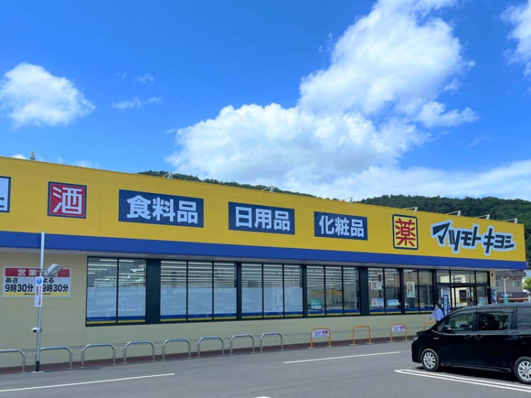 黄色と青の外壁が特徴的なマツモトキヨシ入江町店の外観。建物上部には、食品、日用品、化粧品などが書かれています。