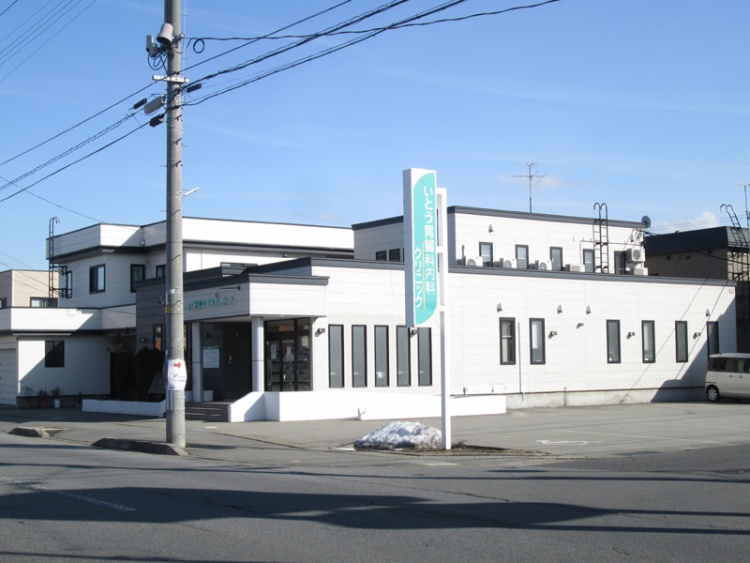 いとう胃腸科内科クリニックの白い建物と看板が道路沿いに見えます。