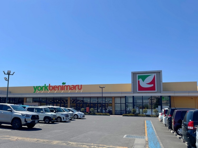広い駐車場とyork beniemaruスーパーの外観。駐車場には複数の車が停められています。