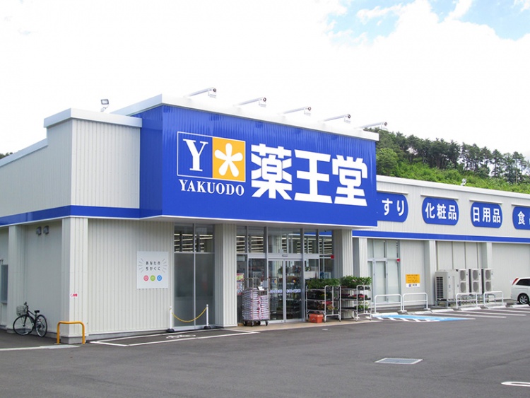 青と黄色が特徴的な薬王堂盛岡三ツ割店の外観。建物上部にはくすり、化粧品、日用品、食品が書かれています。
