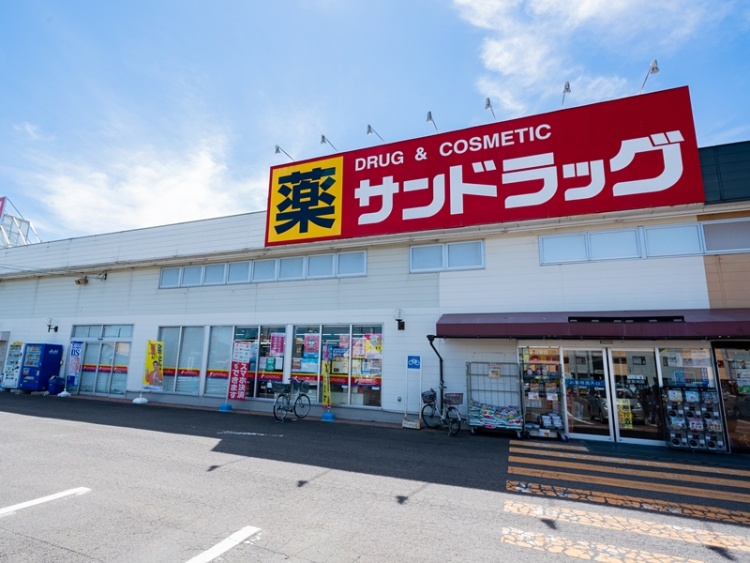 サンドラック八木田店の外観。建物上部には薬、DRUG & COSMETICが書いてあります。