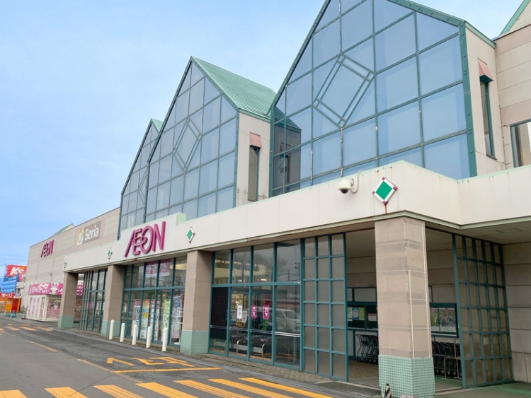 大きなガラス窓と緑色の屋根が特徴のイオン酒田南店の外観。奥にはケーズデンキが見えます。