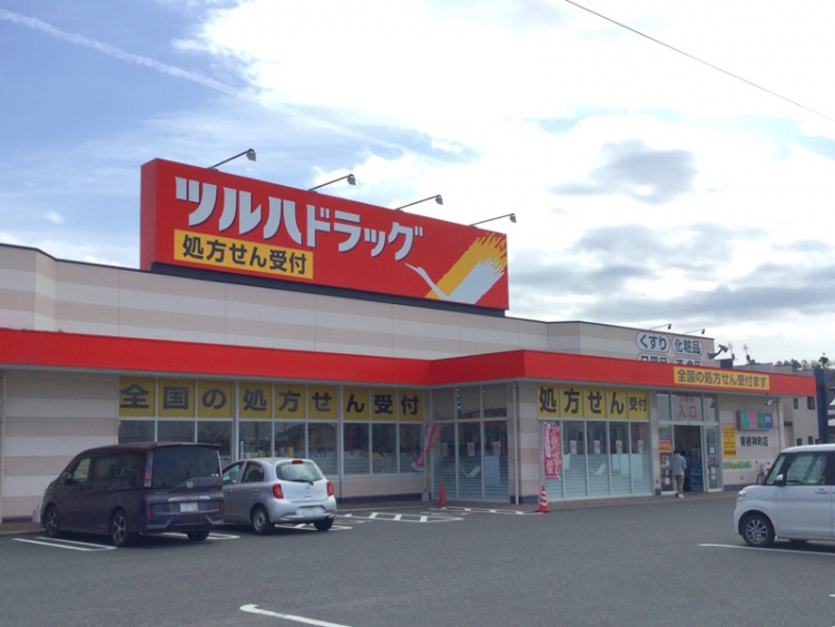 ツルハドラッグ東根神町店の外観。駐車場には数台の車が停められています。処方せん受付の看板が見えます。
