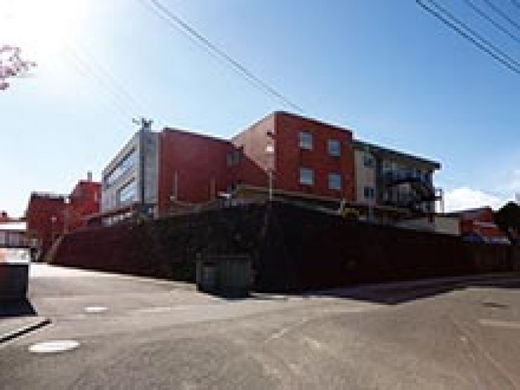 赤レンガ造りの中村第一中学校の校舎の外観。高台に位置しています。