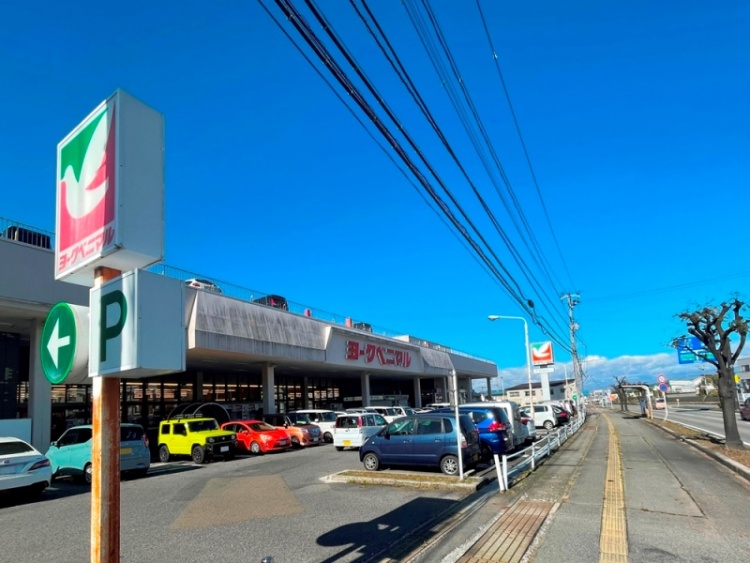 赤い文字が特徴的なヨークベニマル一箕町店の外観。駐車場にはたくさんの車が停められています。