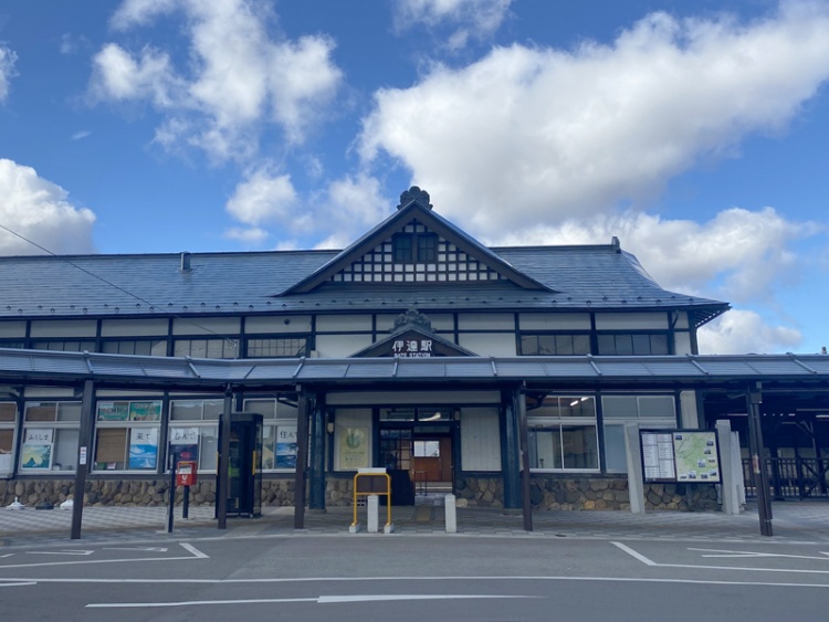 古風な外観の伊達駅の外観。駅前には駐輪場と自動販売機が見えます。