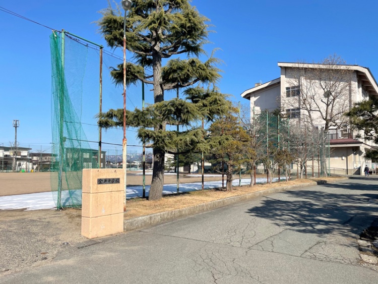 山形市立金井中学校校舎の外観。木々が並んでいます。