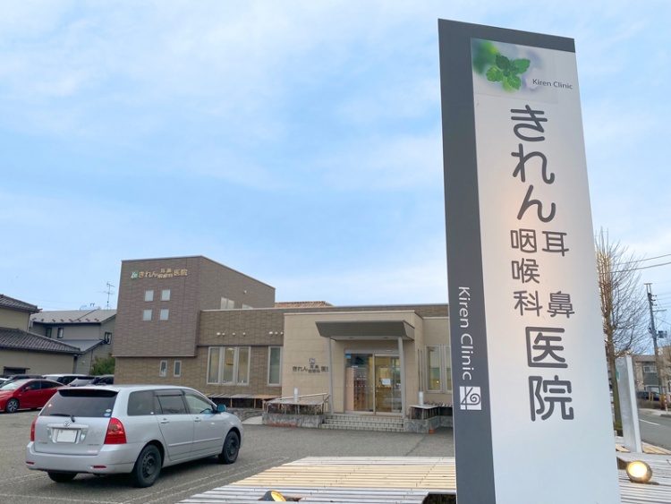 ベージュとブラウンの外壁のきれん耳鼻咽喉科医院の外観。駐車場が見えます。