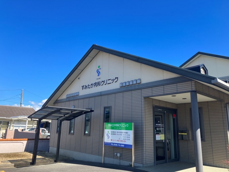 すみたか内科クリニックの外観。明るい屋根付きの玄関とクリニックの看板が見える。