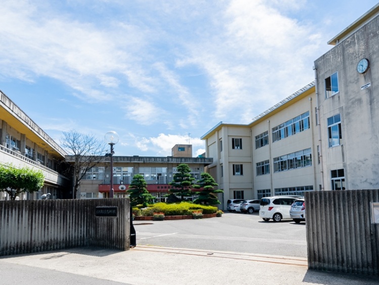 岳陽中学校の校舎の外観。もんの奥には駐車場が見えます。
