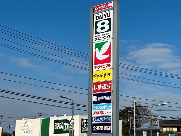 グレーの看板が特徴的なエイトタウン相馬の外観。ダイユーエイト、ヨークベニマル、マツモトキヨシ、しまむらなどの店舗名が表示されています。