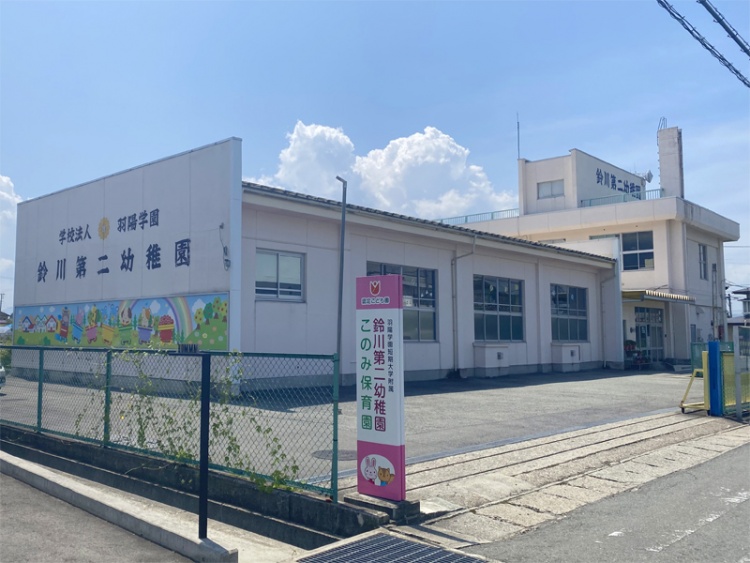 白い建物の鈴川第二幼稚園の外観。建物の壁にはカラフルなイラストが描かれています。
