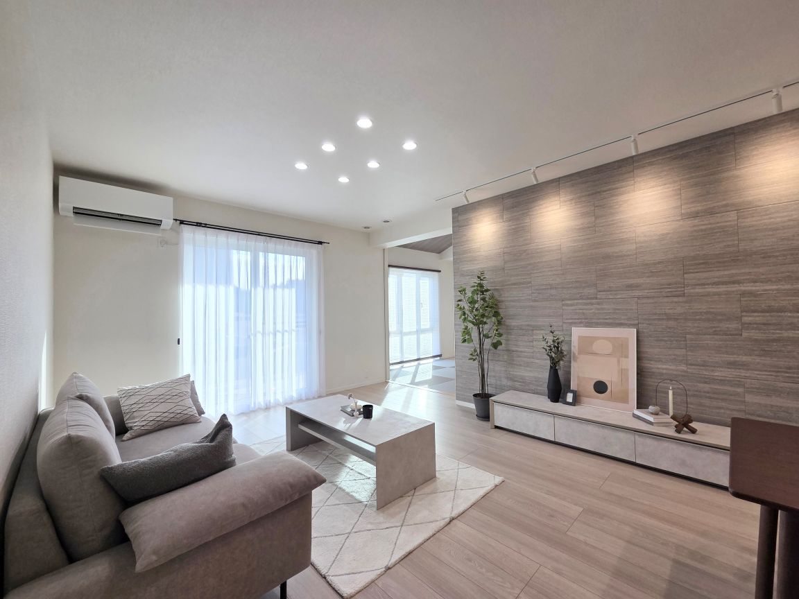 広々としたリビング・ダイニング空間。明るい木目のフローリングが室内に開放感を与え、ダウンライトの照明が空間をやさしく照らしています。