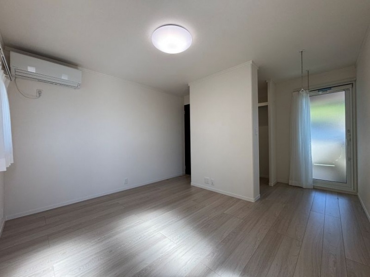 白を基調とした主寝室。エアコン、ウォークインクローゼット、物干し用の金具が天井に設置されています。