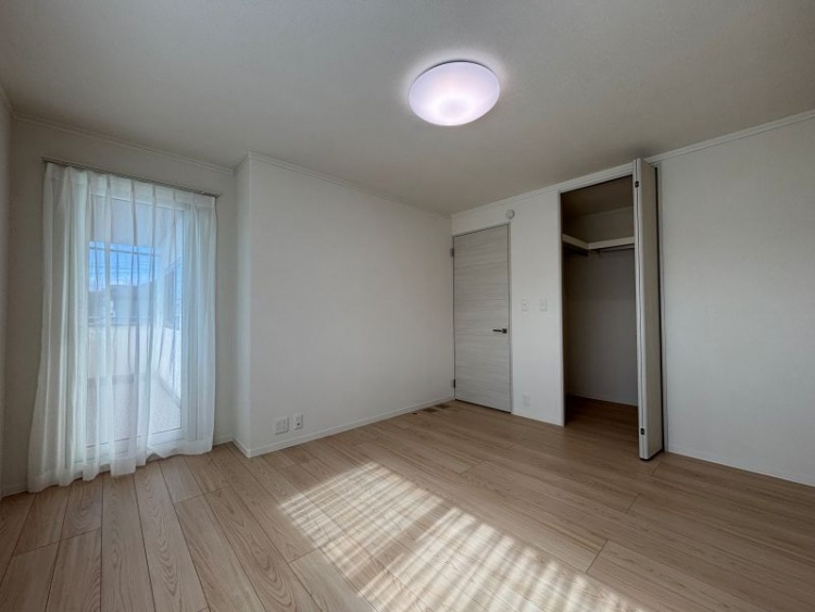 白を基調とした主寝室。バルコニーに出られる大きな窓とウォークインクローゼットが設置されています。