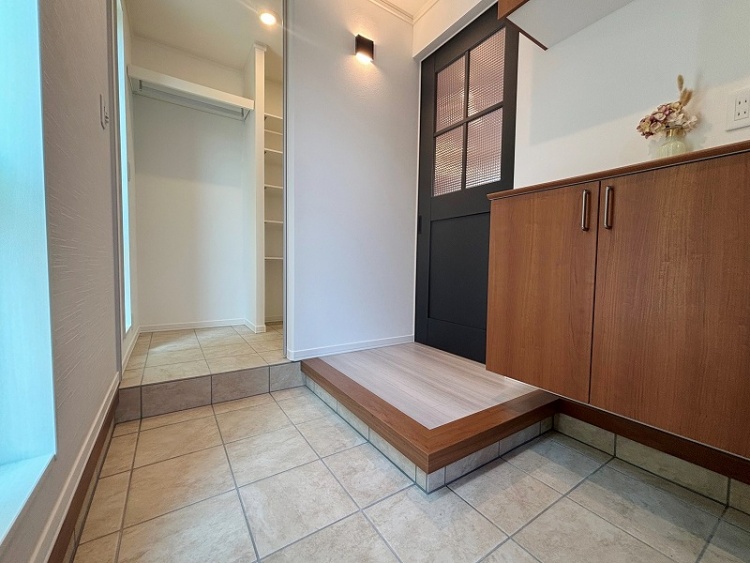 クローゼットの写真です。左側には洋服をかけるためのポールが設置され、右側には高さを調節できる5段の棚があります。白を基調としたシンプルなデザインで、収納スペースが十分に確保されています。